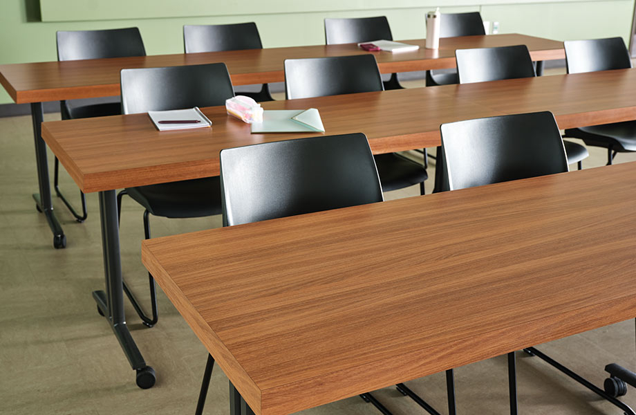 Three rows of long conference tables in Oiled Legno Formica Laminate with black chairs